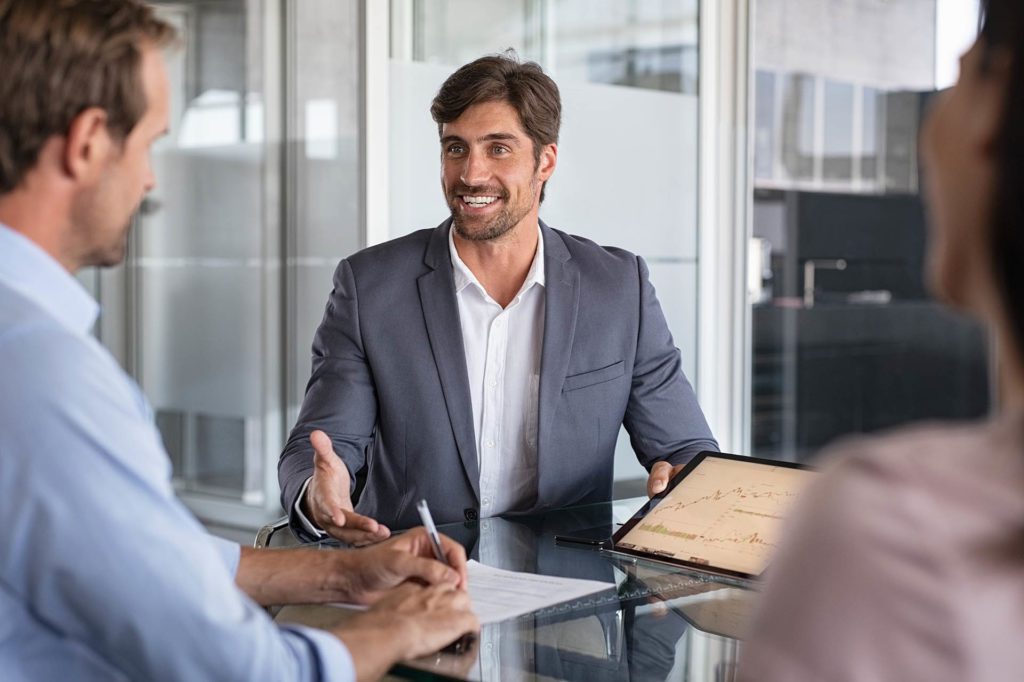 A professional financial advisor consulting with a client in a modern office setting, discussing financial documents and planning strategies. 