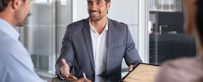 A professional financial advisor consulting with a client in a modern office setting, discussing financial documents and planning strategies.